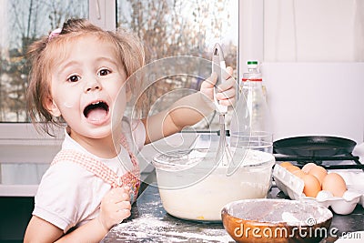 A little cute girl preparing the dough in the kitchen at home Stock Photo