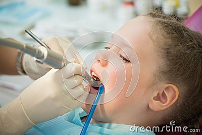 Little cute girl sitting in chair at dentist clinic during dental checkup and treatment, closeup portrait. Stock Photo