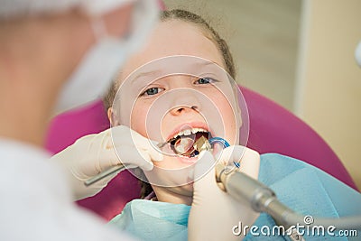 Little cute girl sitting in chair at dentist clinic during dental checkup and treatment, closeup portrait. Stock Photo