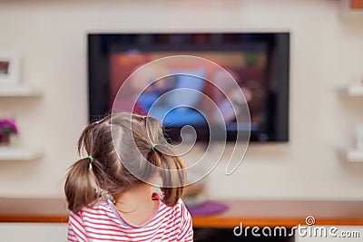 Little cute girl watching television with attention Stock Photo