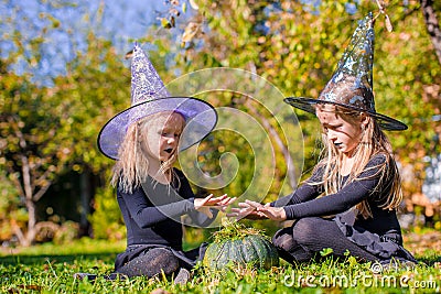 Little cute girls casting a spell on Halloween in Stock Photo