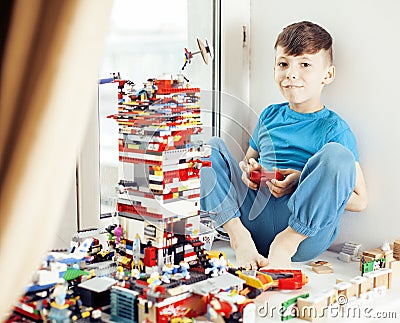 Little cute preschooler boy playing lego toys at home happy smiling, lifestyle children concept Stock Photo