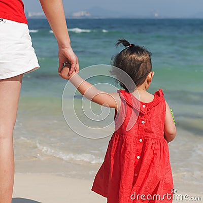 Little daughter holding moms hand watching sea Stock Photo