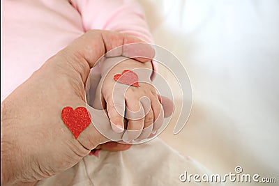 Little daughter holds dad by the finger. hearts for the day of p Stock Photo