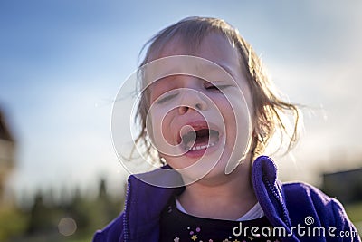 Little disheveled girl crying outdoors Stock Photo