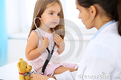 Little doctor examining a ntoy bear patient by stethoscope Stock Photo
