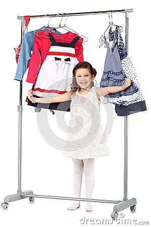 Little fashionable girl chooses clothes in a wardrobe Stock Photo