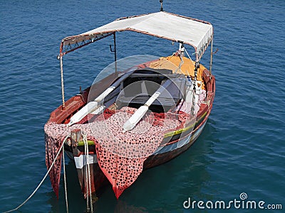 Little fishing boat floating on bright blue sea Stock Photo