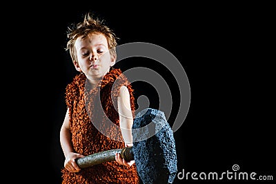 Little funny angry warrior boy. Neanderthal or a Cro-Magnon. Ancient caveman, male savage Stock Photo