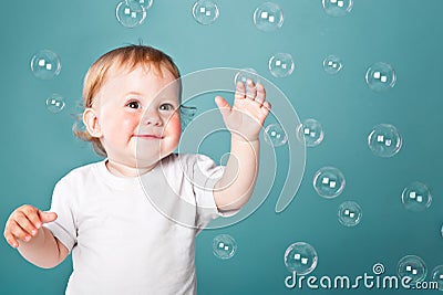 A little funny boy is playing with bubbles Stock Photo