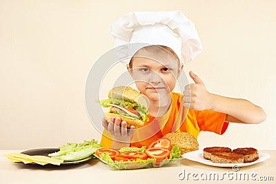 Little funny chef expressive enjoys cooked hamburger Stock Photo