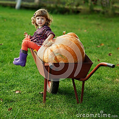 Little funny girl with pumpkins Stock Photo