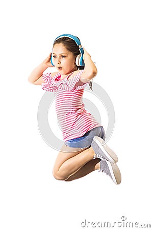 Little funny jumping and shouting little caucasian girl with a headphones Stock Photo