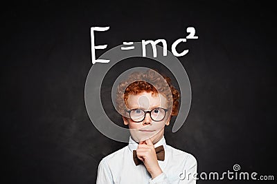 Little genius portrait. Young child boy student on chalkboard with science formula Stock Photo