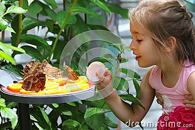 Little girl amazed by butterflies Stock Photo