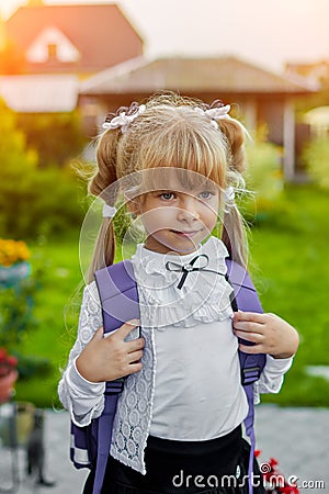Little girl with a backpack near the school Stock Photo