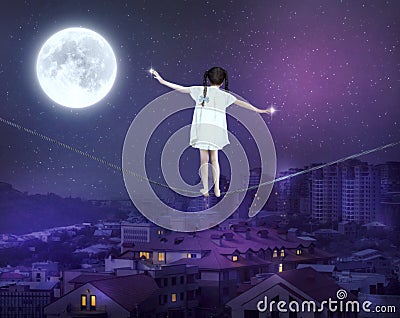 Little girl balancing on a tightrope Stock Photo