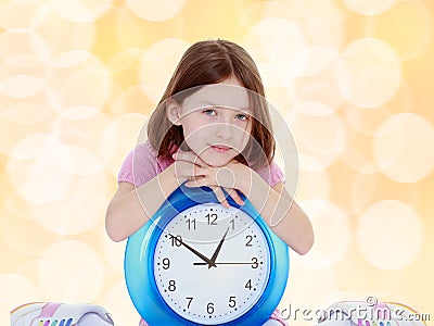 Little girl with a big clock. Stock Photo