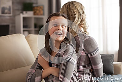 Little girl with a big smile and braces sitting back to back Stock Photo