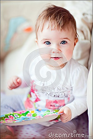 Little girl with blue eyes sitting in the crib Stock Photo