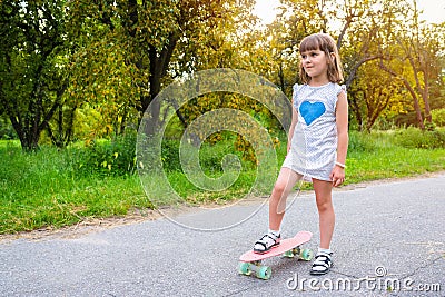 Little girl on a board on a sunny day in the park Stock Photo