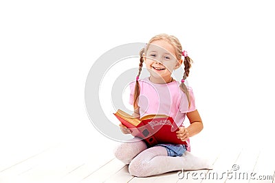 Joyful little girl with books sits on a white floor. Stock Photo