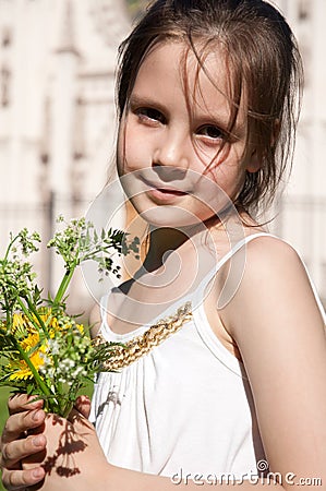 Little girl with the bouquet of the field flowers Stock Photo