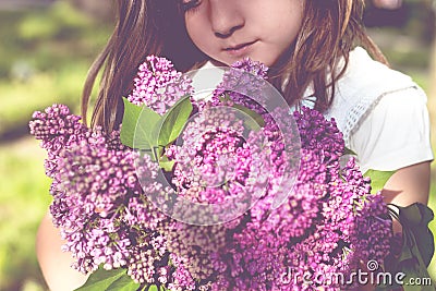 Little girl with bouquet of lilac in her hands Stock Photo