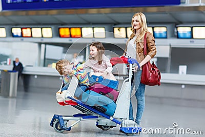 Little girl and boy and young mother with suitcases on airport Stock Photo