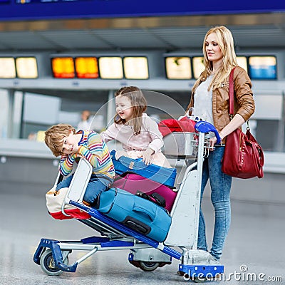 Little girl and boy and young mother with suitcases on airport Stock Photo