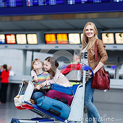 Little girl and boy and young mother with suitcases on airport Stock Photo