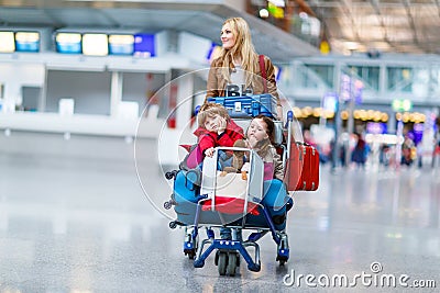 Little girl and boy and young mother with suitcases on airport Stock Photo