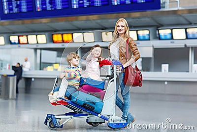 Little girl and boy and young mother with suitcases on airport Stock Photo