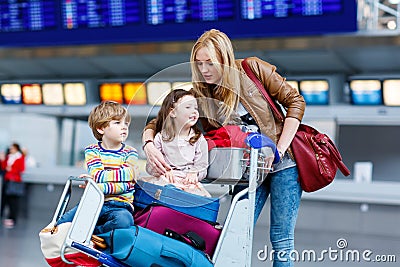Little girl and boy and young mother with suitcases on airport Stock Photo