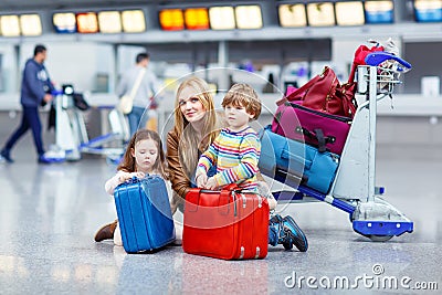 Little girl and boy and young mother with suitcases on airport Stock Photo