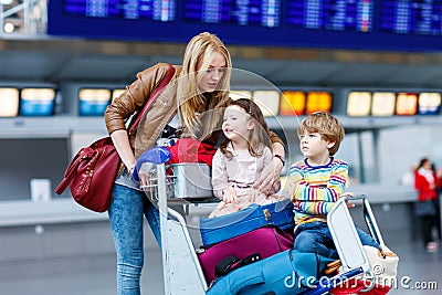 Little girl and boy and young mother with suitcases on airport Stock Photo