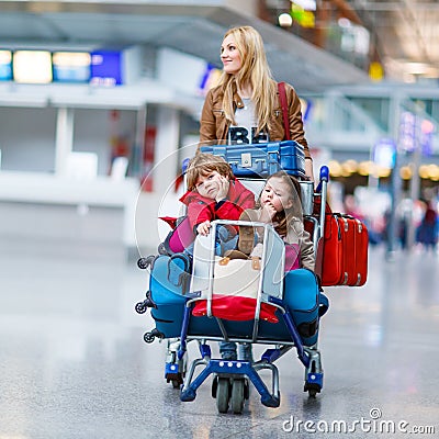 Little girl and boy and young mother with suitcases on airport Stock Photo