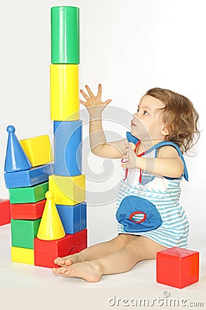 A little girl builds a house. Stock Photo