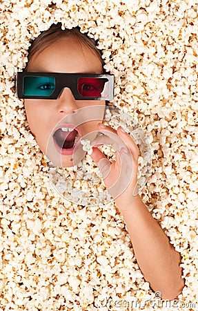 Little girl buried in popcorn Stock Photo