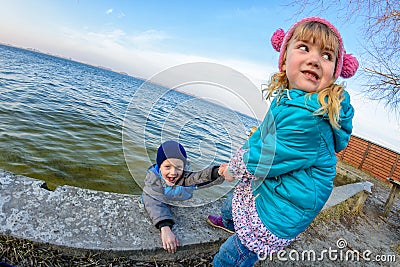 Little girl calls for help and rescues the boy out of the water Stock Photo