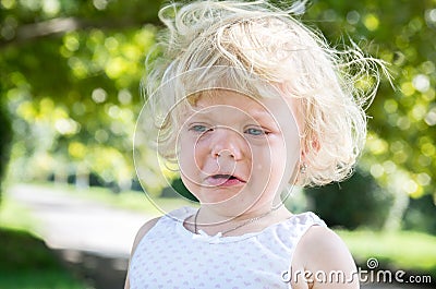 Little girl child blonde bitterly cries. Stock Photo