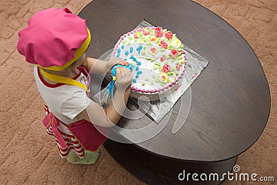 Little girl children decorate cream cake Stock Photo