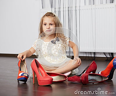 Little girl choosing mother shoes Stock Photo