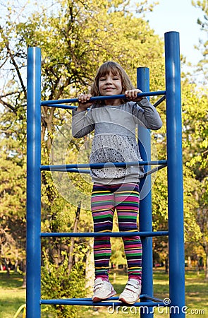 Little girl climb on playground Stock Photo