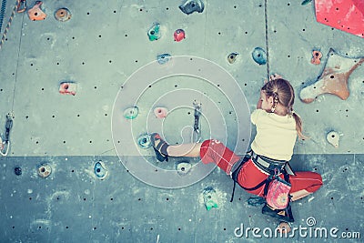 Little girl climbing a rock wall Stock Photo