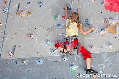 Little girl climbing a rock wall Stock Photo