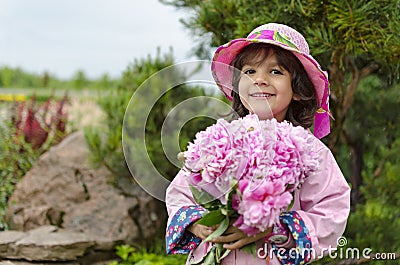 The little girl close in a pink hat and a raincoat Stock Photo