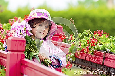 The little girl close in a pink hat and a raincoat. Stock Photo