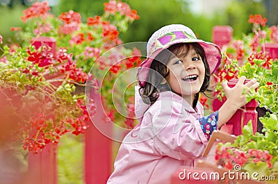 The little girl close in a pink hat and a raincoat. Stock Photo