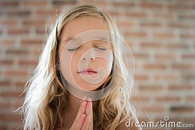 Little girl closed her eyes and prays Stock Photo